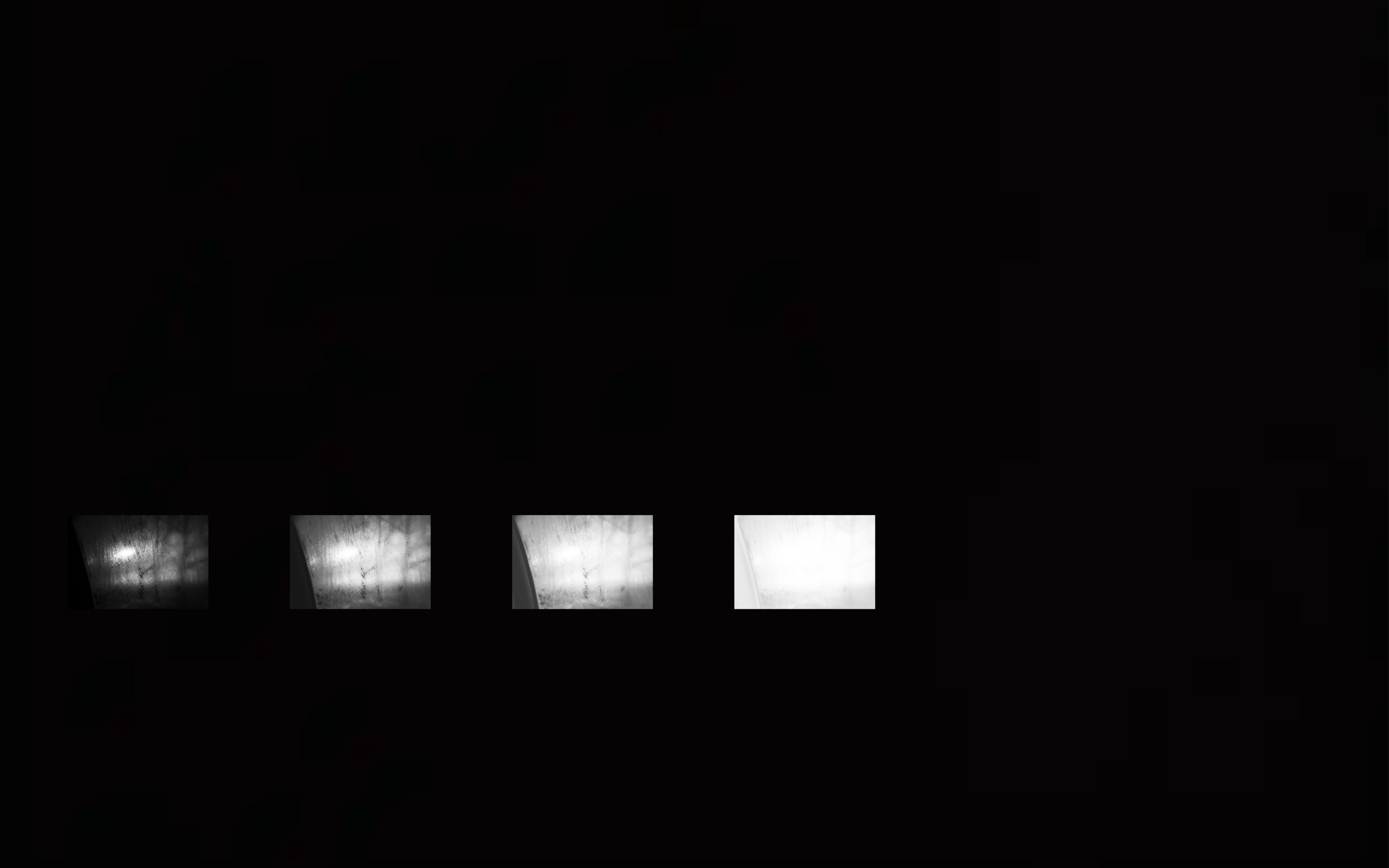 Four illuminated window-like images against a black field
